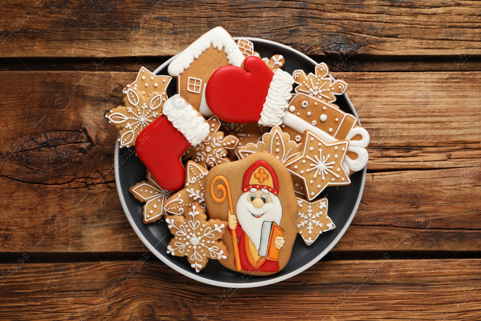 Photo of Tasty gingerbread cookies on wooden table, top view. St. Nicholas Day celebration