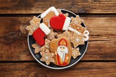 Photo of Tasty gingerbread cookies on wooden table, top view. St. Nicholas Day celebration