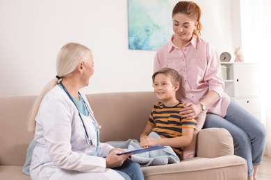 Family doctor visiting ill child at home