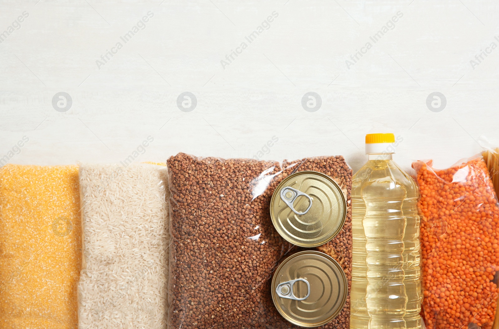 Photo of Many different products and space for text on white wooden background, flat lay. Food donation