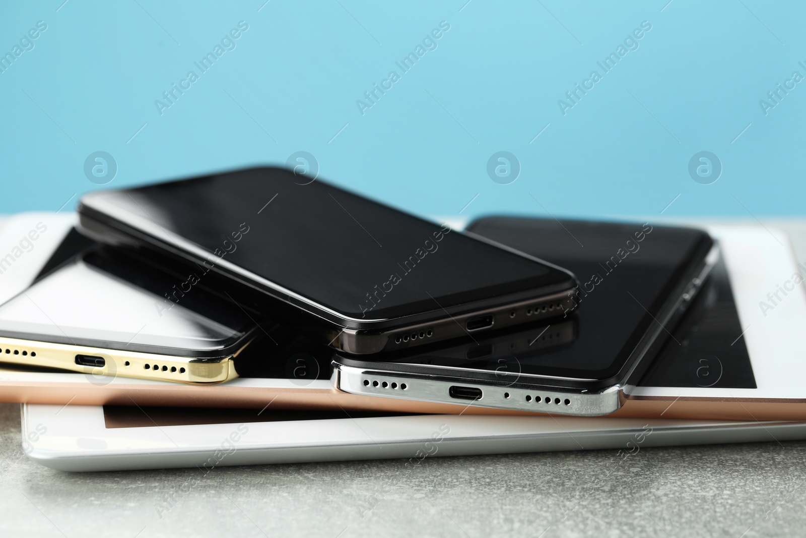 Photo of Stack of electronic devices on grey table, closeup