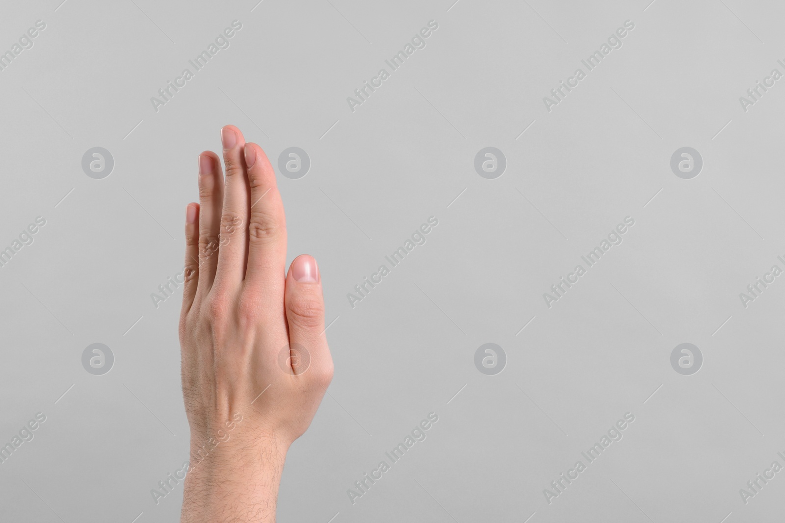 Photo of Man giving high five on grey background, closeup of hand. Space for text