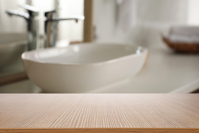 Image of Empty wooden table and blurred view of stylish bathroom interior