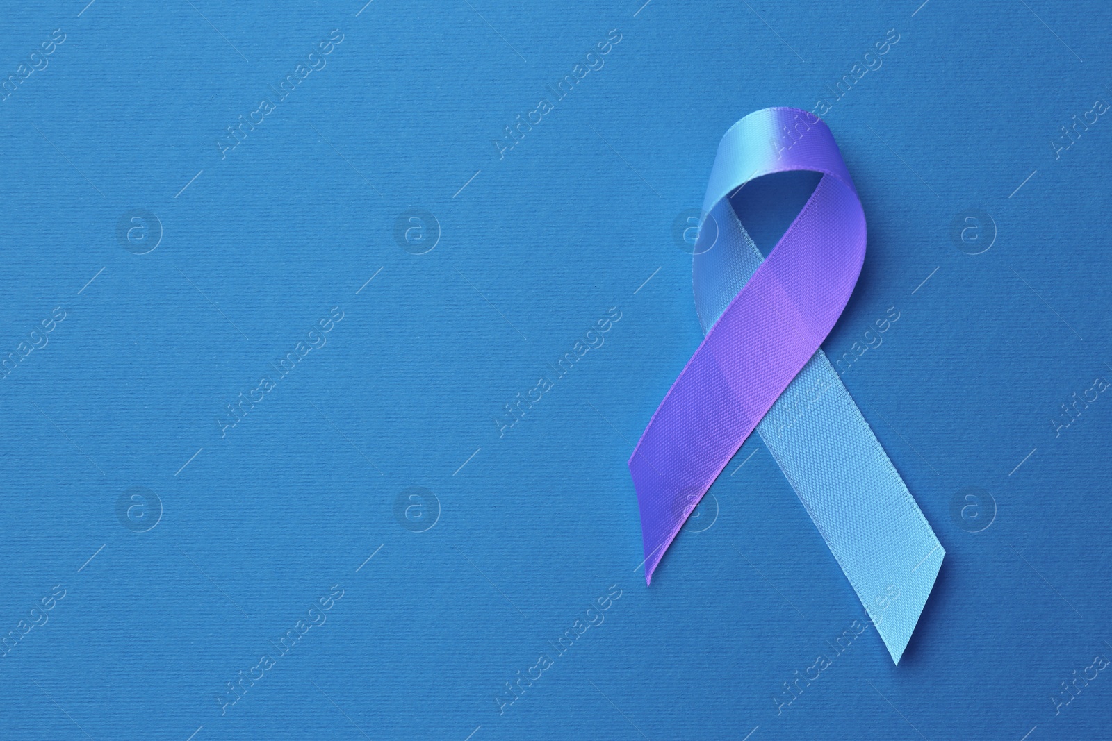 Image of World Arthritis Day. Blue and purple awareness ribbon on color background, top view. Space for text