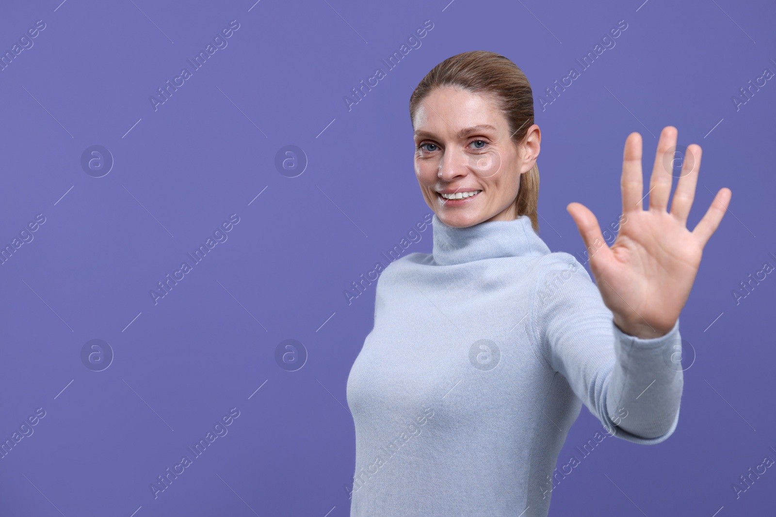 Photo of Woman giving high five on purple background, space for text