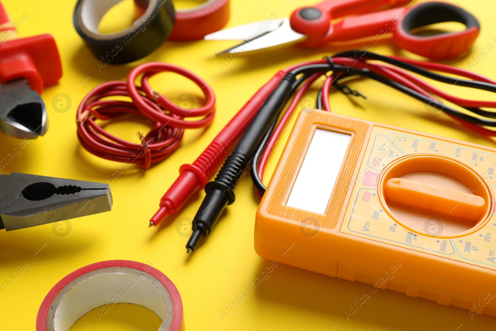 Photo of Set of electrician's tools and accessories on yellow background, closeup