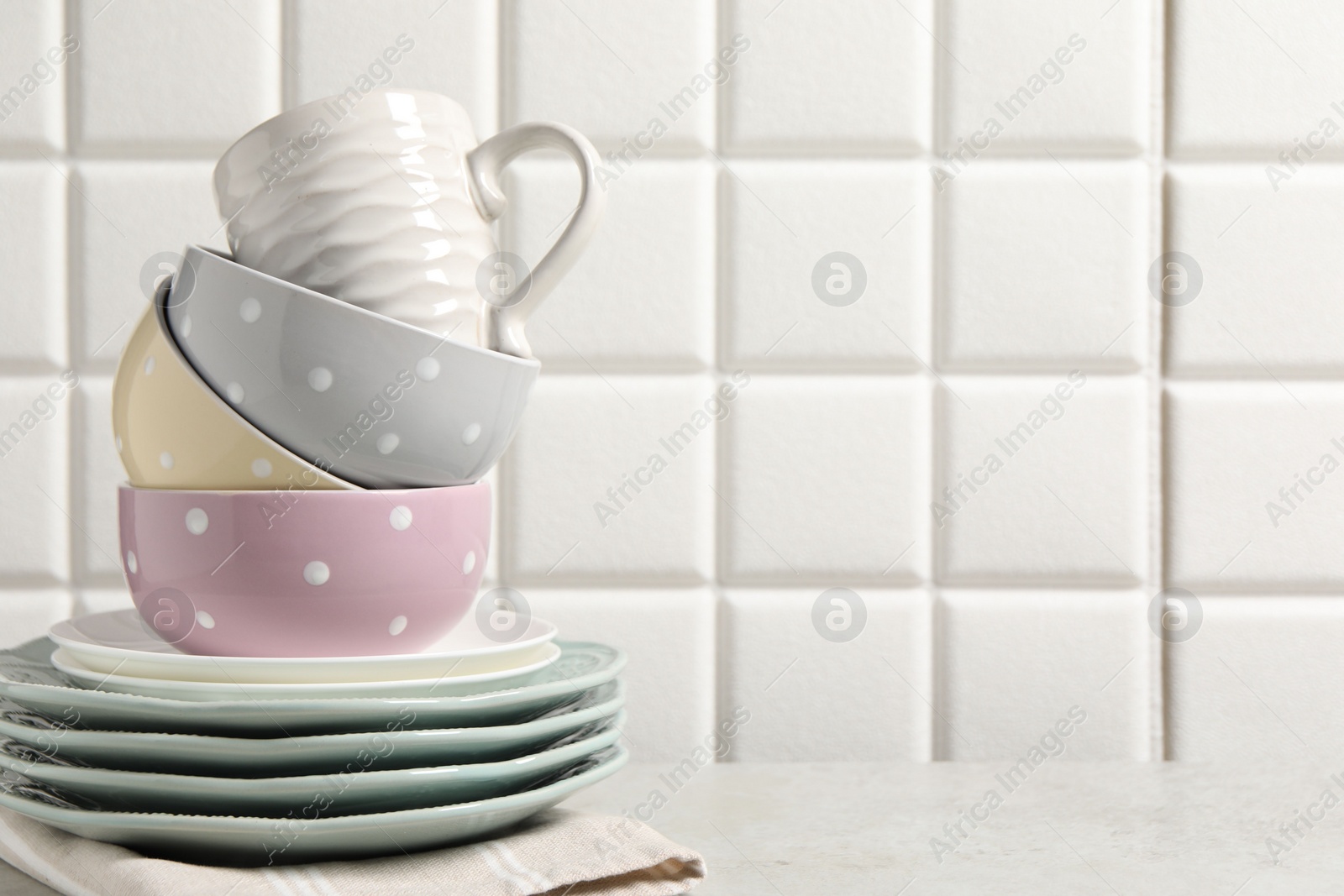 Photo of Beautiful ceramic dishware and cup on light grey table, space for text