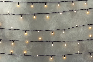 Christmas lights hanging on grey stone wall