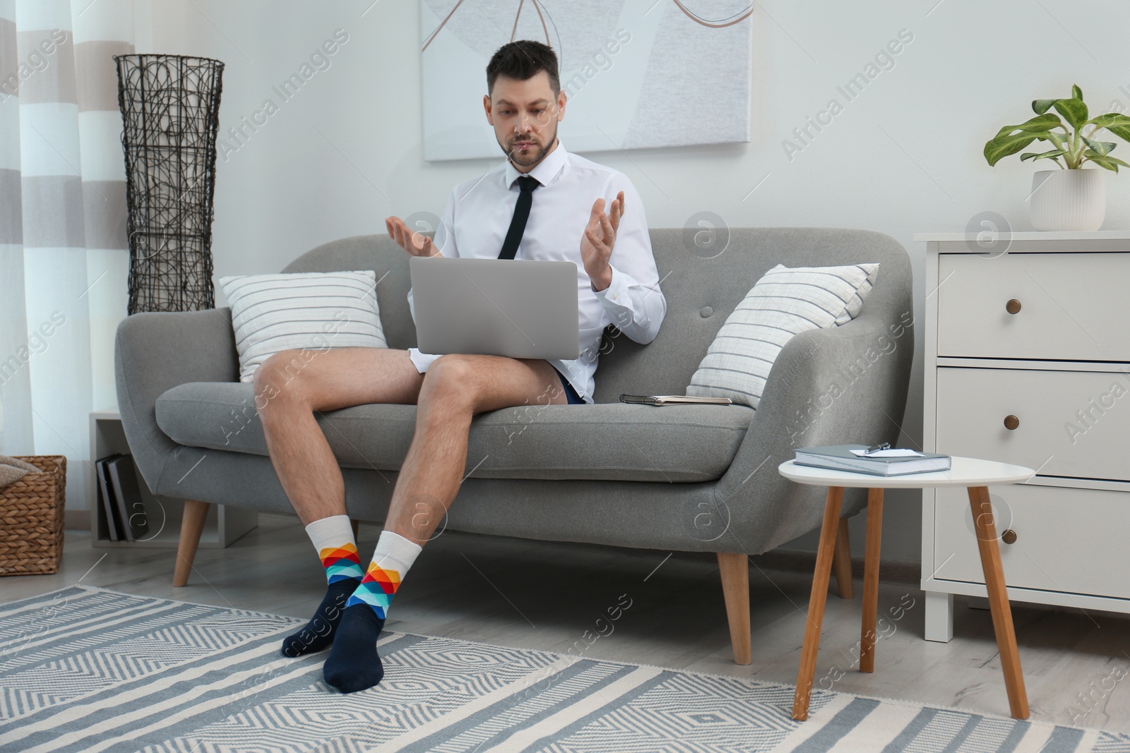 Photo of Businessman wearing shirt and underwear during video call at home