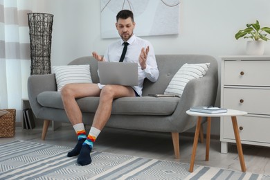 Businessman wearing shirt and underwear during video call at home