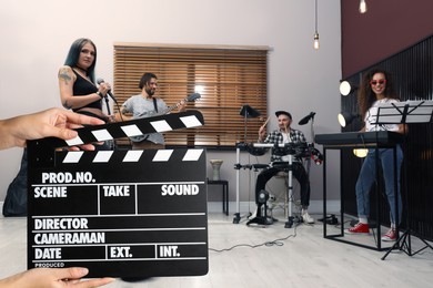 Image of Shooting movie. Second assistant camera holding clapperboard in front of band (actors) at studio (film set)