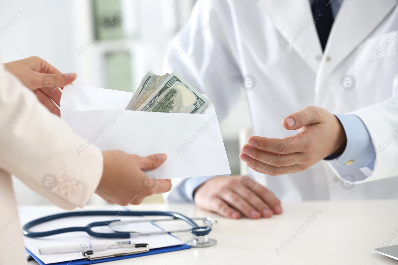 Photo of Patient giving bribe to doctor in clinic, closeup. Corrupted medicine