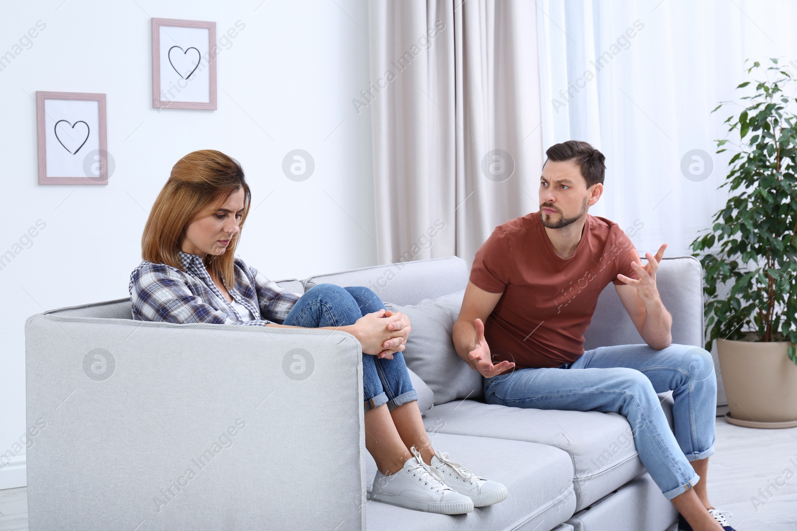 Photo of Couple arguing in living room. Relationship problems