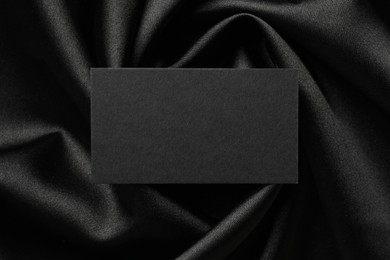 Blank business card on black fabric, top view. Mockup for design