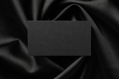 Photo of Blank business card on black fabric, top view. Mockup for design