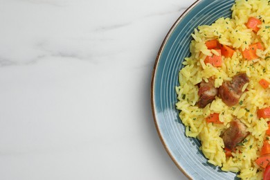 Photo of Delicious pilaf with meat on white marble table, top view. Space for text