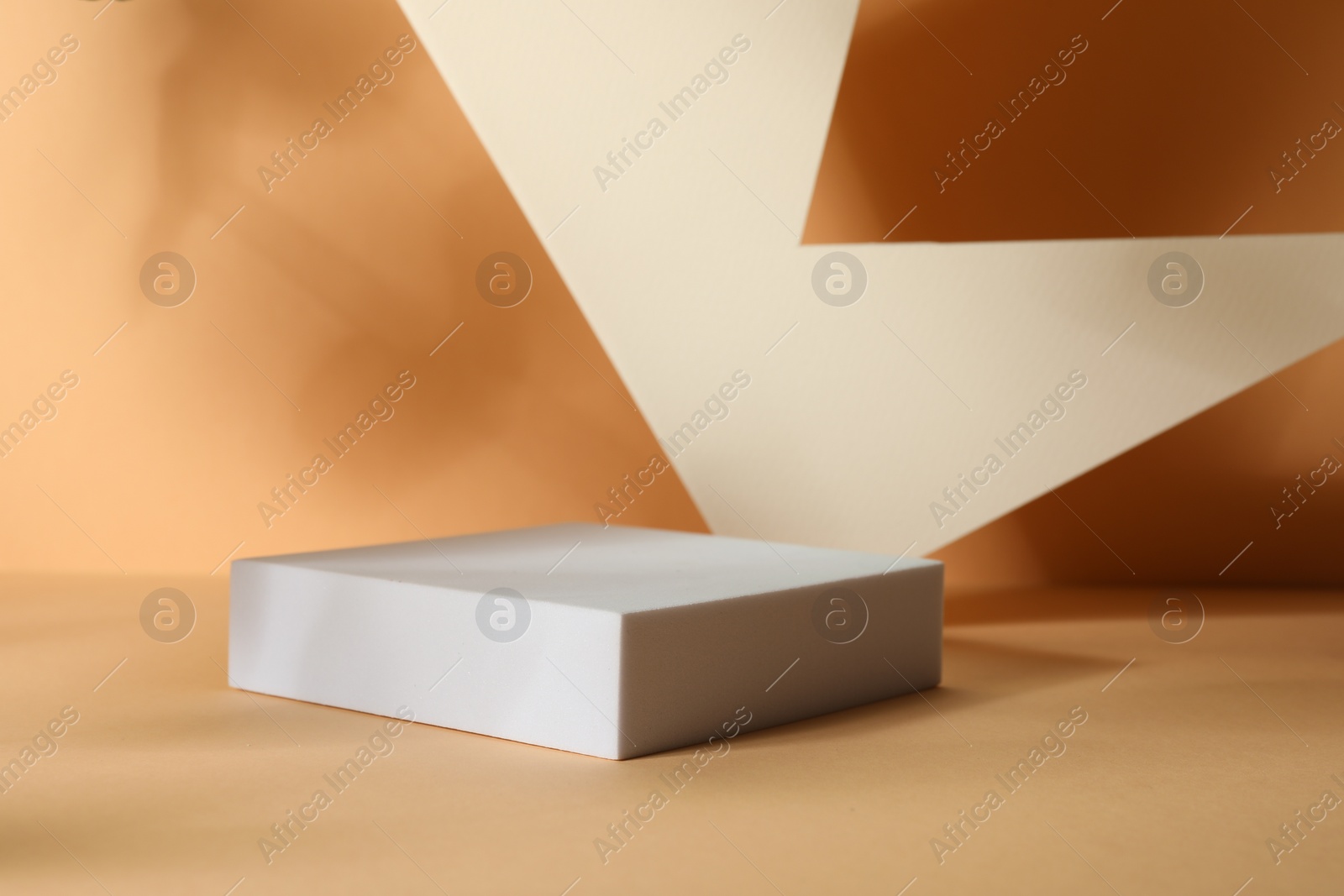 Photo of Presentation of product. Podium and paper on orange background