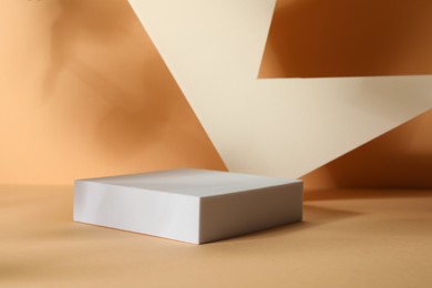 Photo of Presentation of product. Podium and paper on orange background