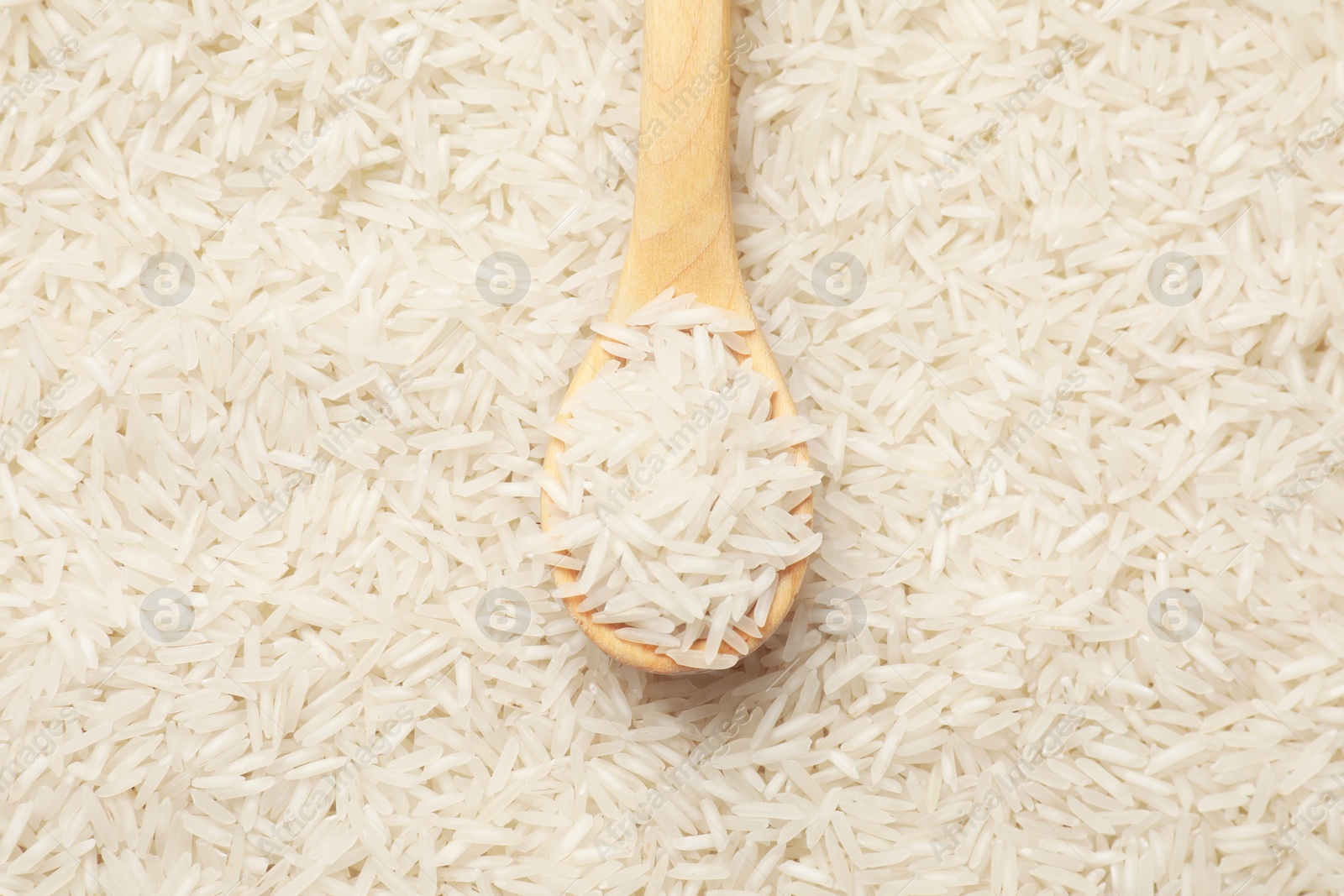 Photo of Raw basmati rice and spoon, top view