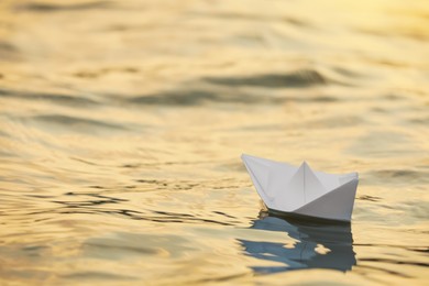 Paper boat floating on water outdoors. Space for text