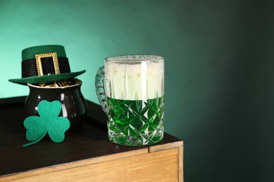 St. Patrick's day celebration. Green beer, leprechaun hat, pot of gold and decorative clover leaf on wooden table. Space for text