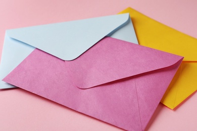 Colorful paper envelopes on pink background, closeup