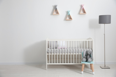 Photo of Cute baby room interior with modern crib