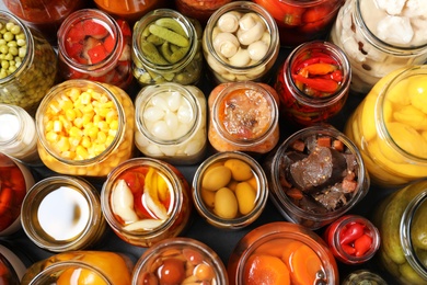 Open jars with pickled vegetables on grey table, flat lay