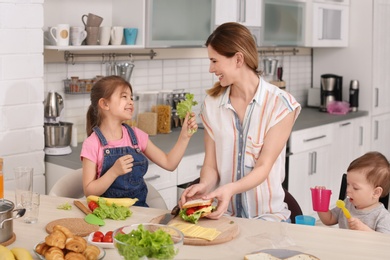 Photo of Housewife preparing dinner with her children on kitchen