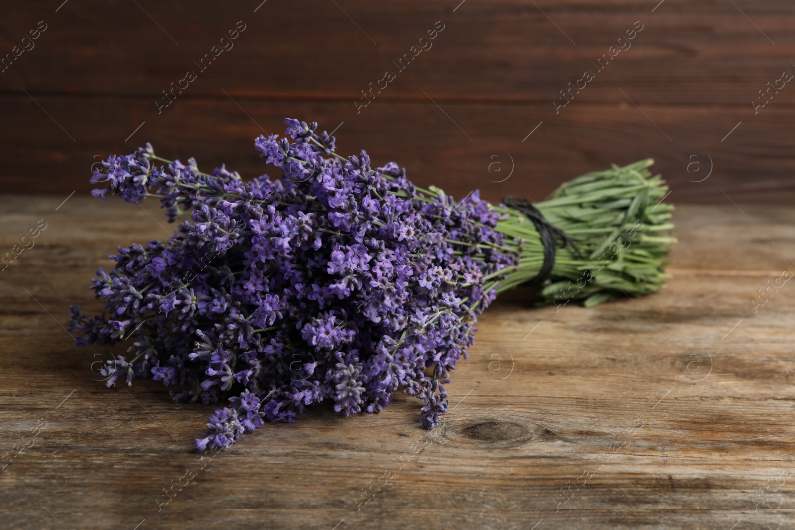 Photo of Beautiful fresh lavender bouquet on wooden table