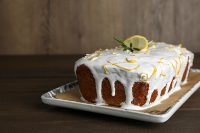 Photo of Tasty lemon cake with glaze on wooden table, closeup. Space for text