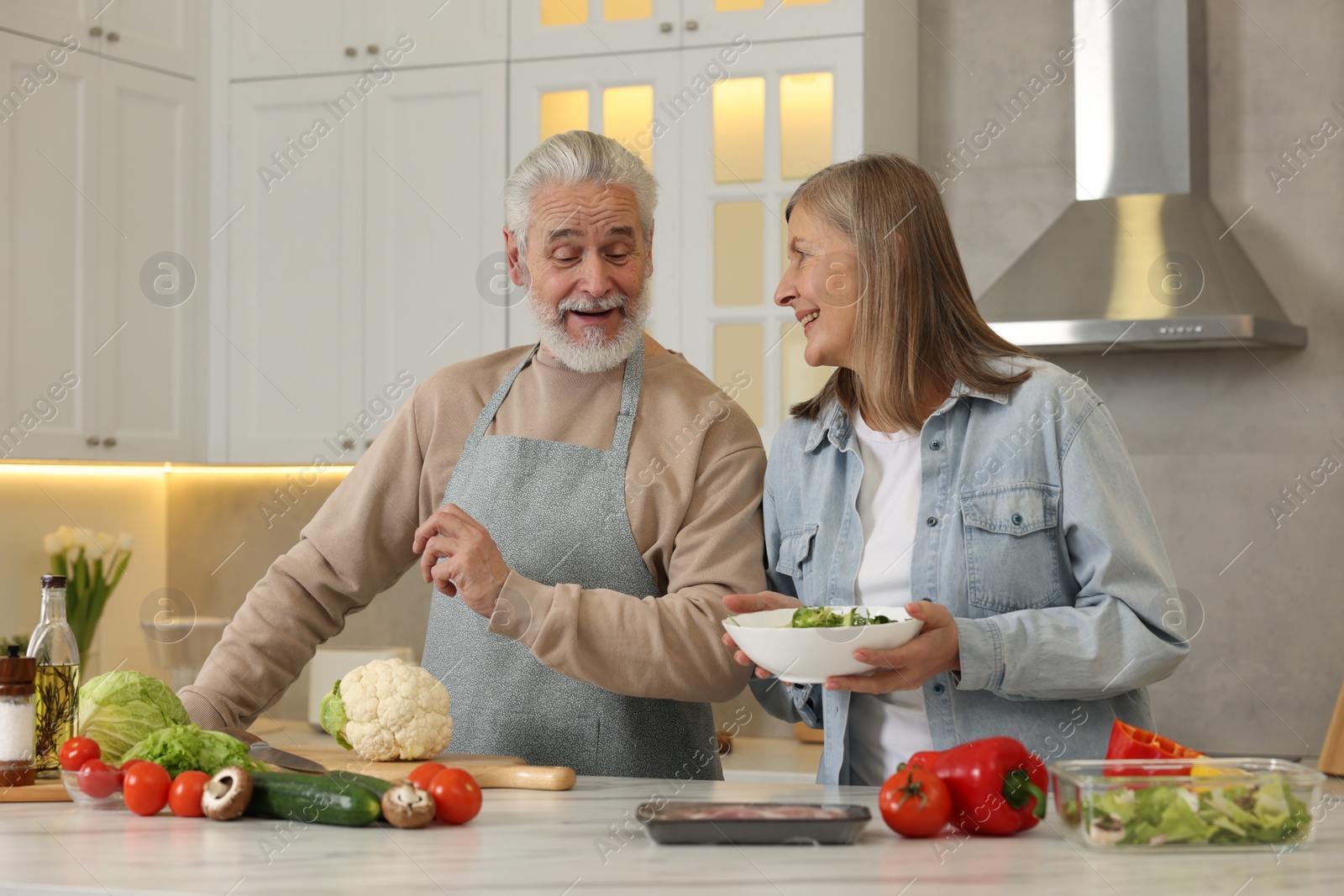 Photo of Happy senior couple cooking together in kitchen