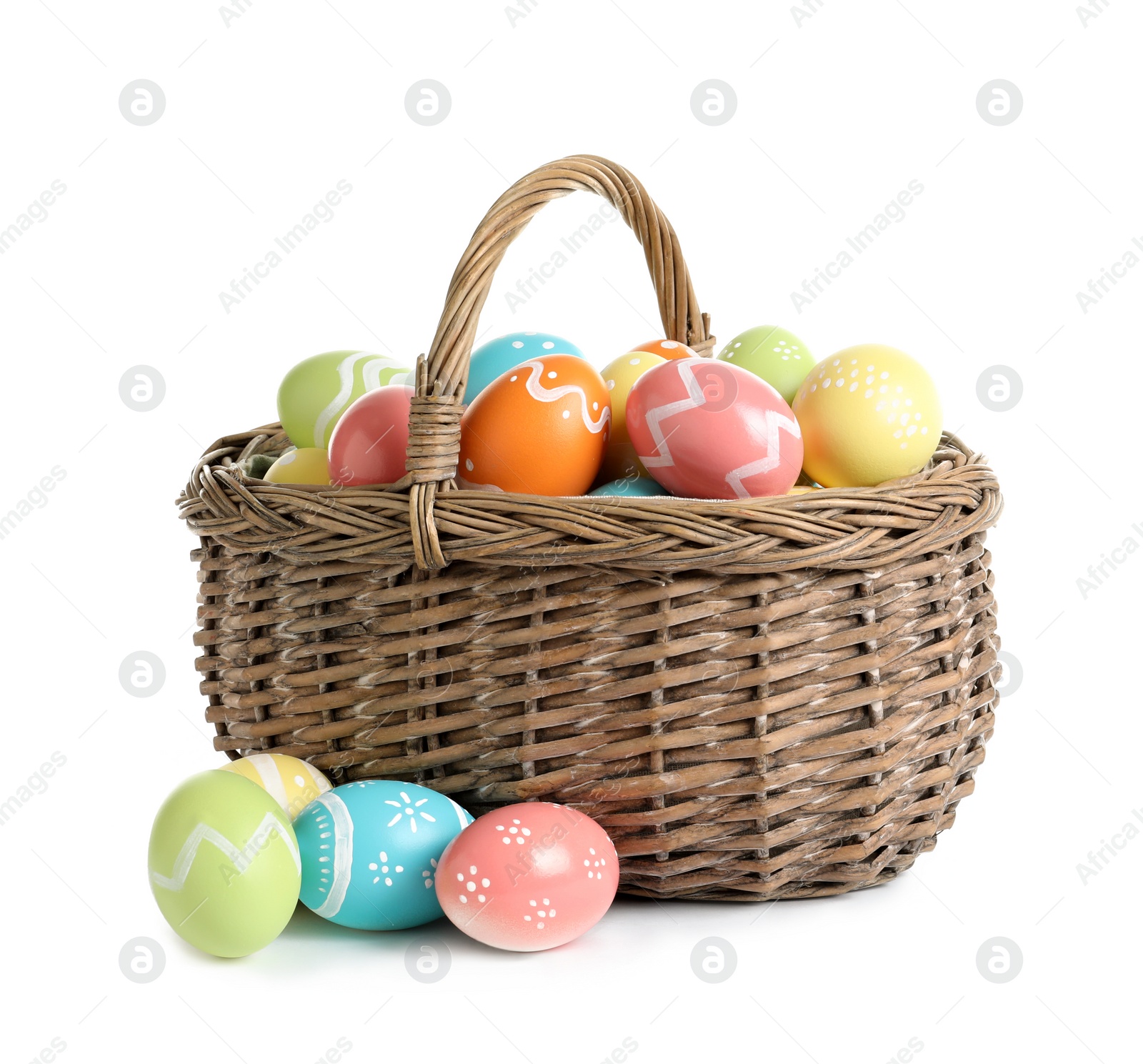 Photo of Wicker basket with painted Easter eggs on white background