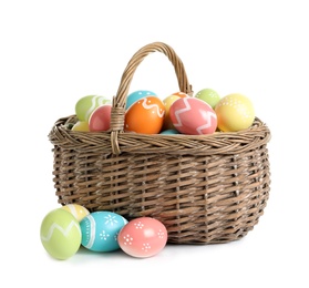 Wicker basket with painted Easter eggs on white background