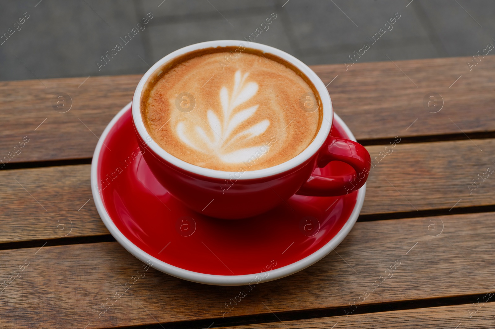 Photo of Cup of aromatic coffee on wooden table, closeup