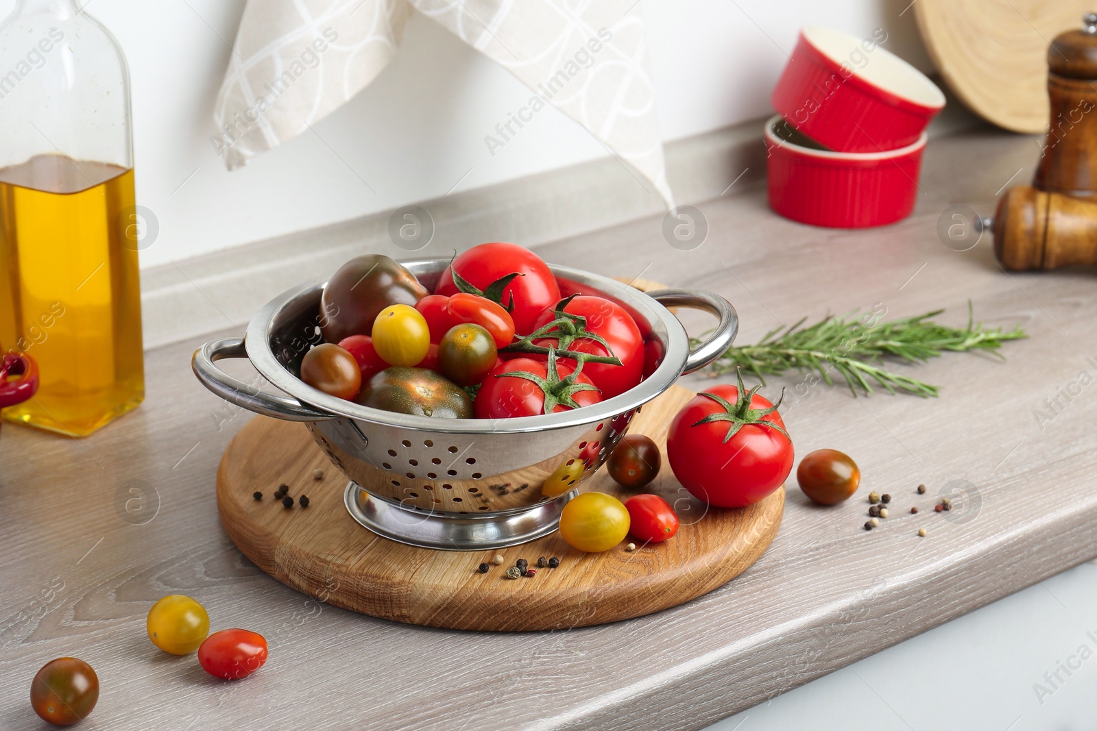 Photo of Metal colander with tomatoes on countertop in kitchen