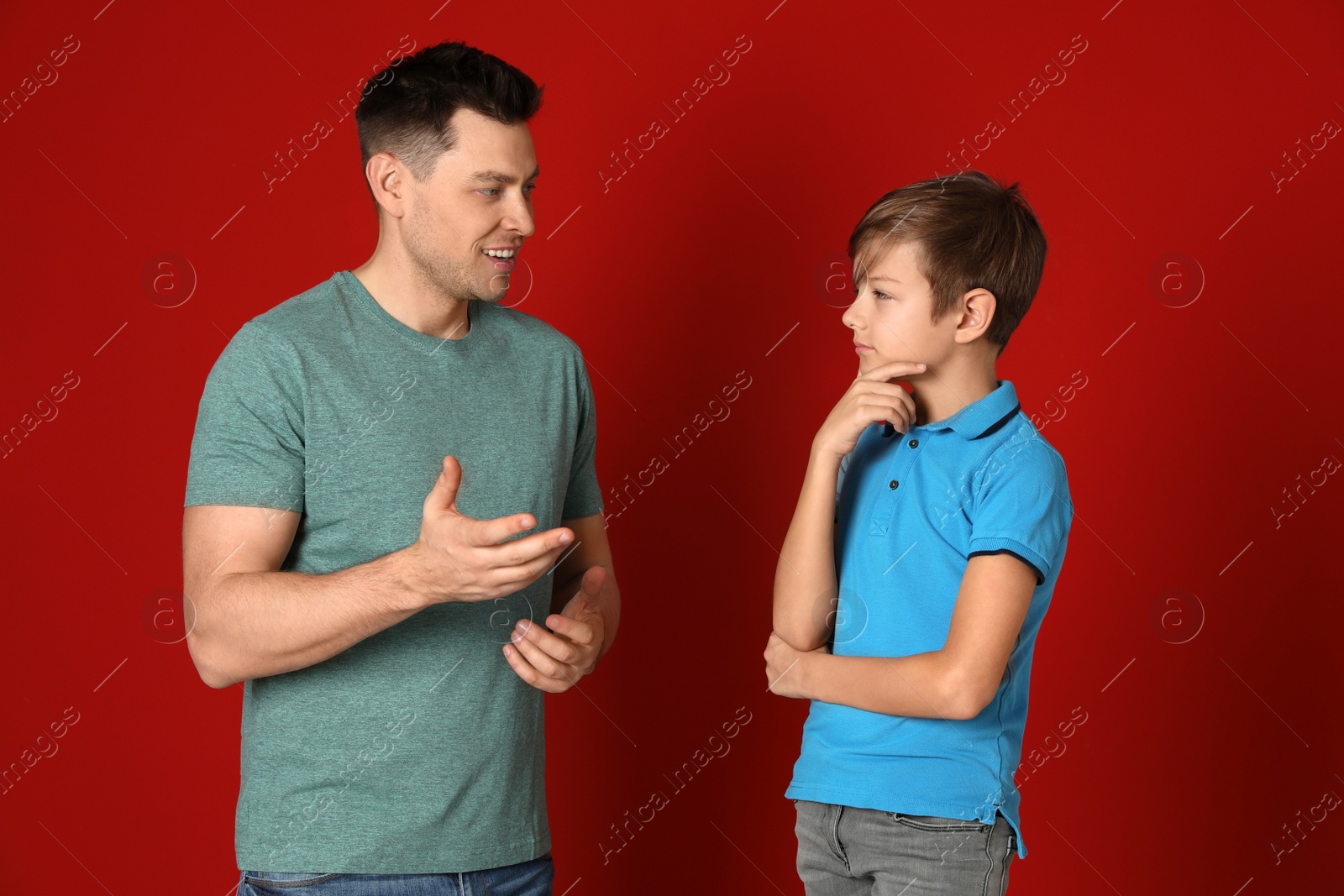 Photo of Dad talking with his son on color background