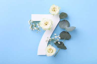 Paper number 7, beautiful flowers and eucalyptus branch on light blue background, top view
