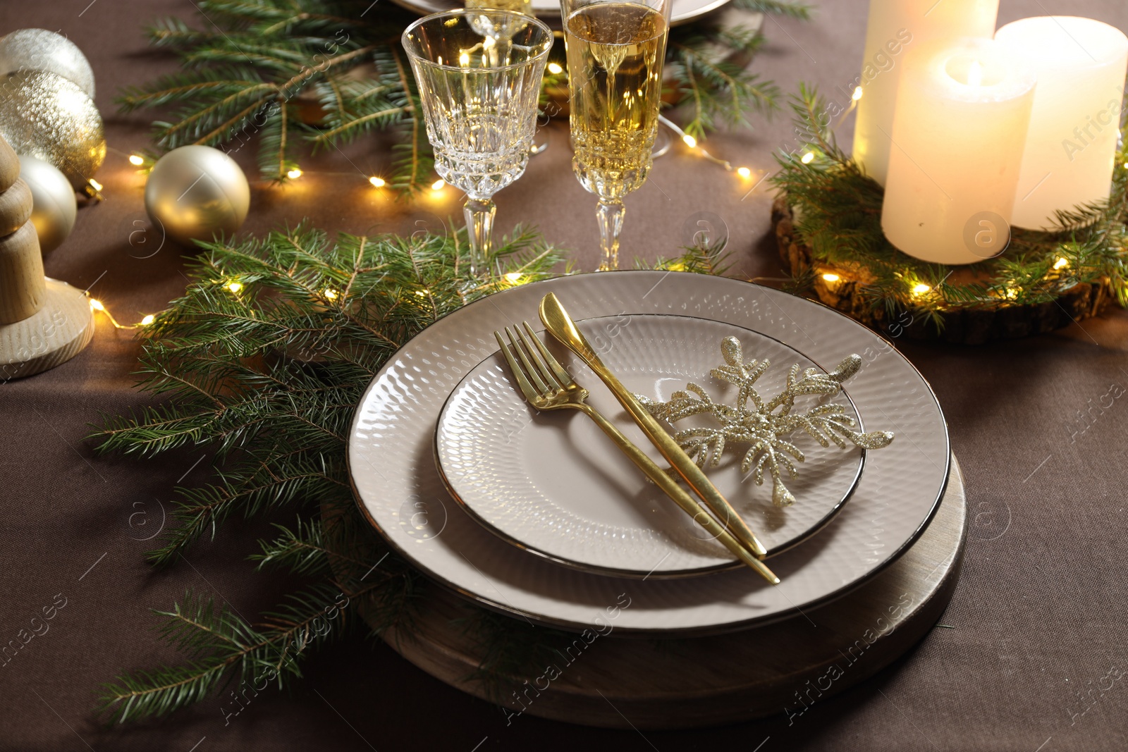 Photo of Christmas table setting with burning candles and festive decor