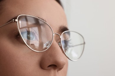 Photo of Woman wearing glasses on blurred background, closeup