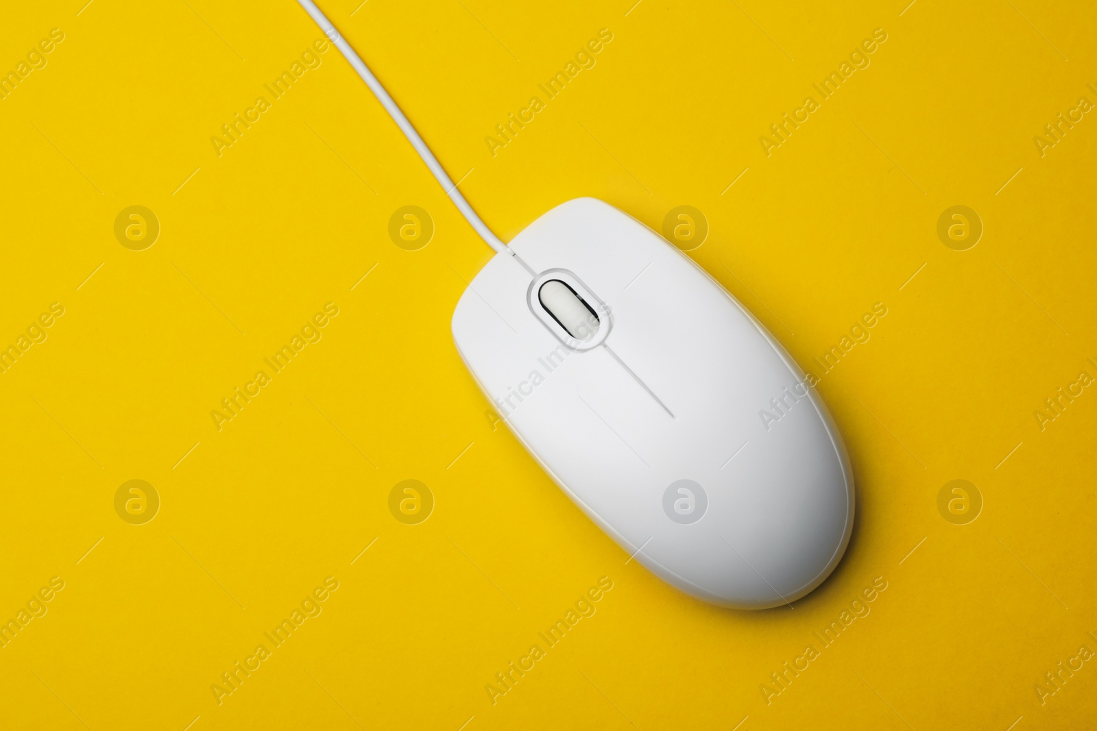 Photo of Wired computer mouse on yellow background, top view