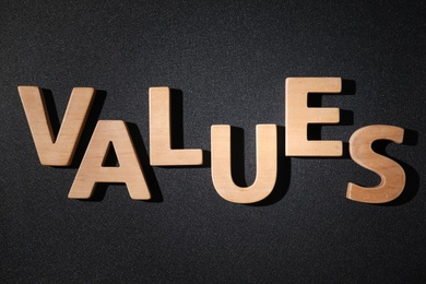 Photo of Word VALUES made of wooden letters on black background, flat lay