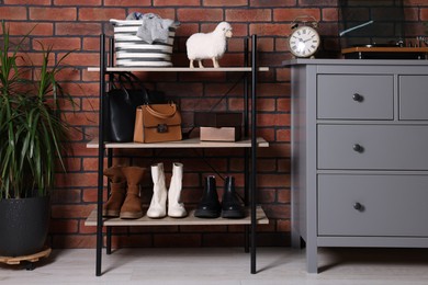 Beautiful hallway interior with chest of drawers and shoe storage bench near red brick wall