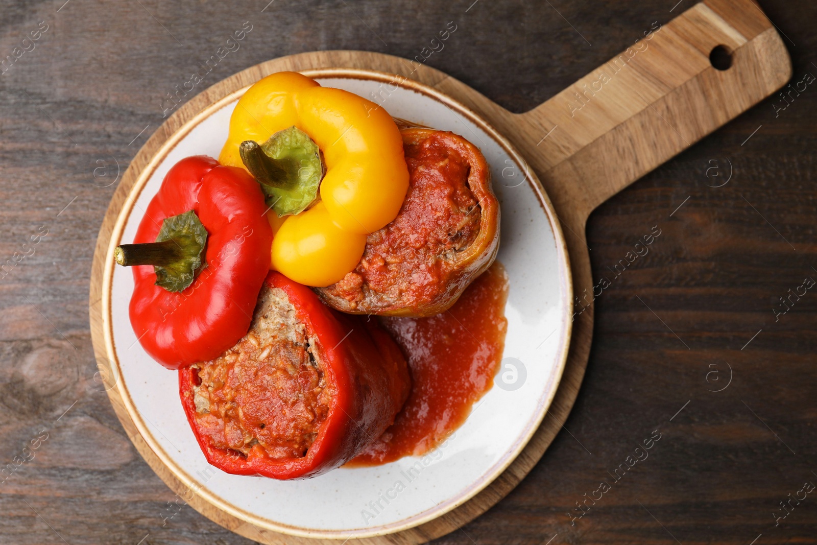 Photo of Delicious stuffed bell peppers served on wooden table, top view