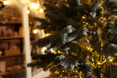 Photo of Beautiful decorated Christmas tree with festive lights on blurred background, closeup. Space for text