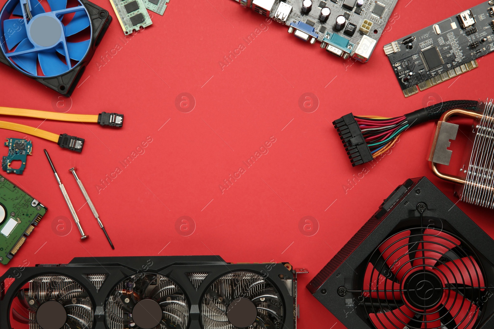 Photo of Frame of graphics card and other computer hardware on red background, flat lay. Space for text