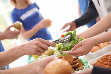 Volunteers serving food to poor people, closeup