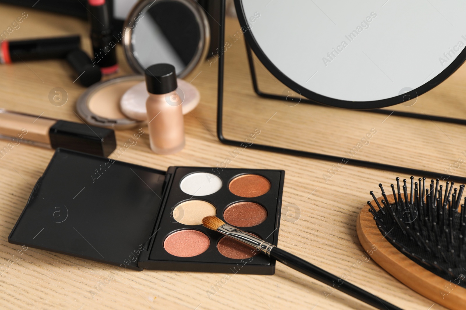 Photo of Eyeshadows and makeup brush on dressing table, closeup