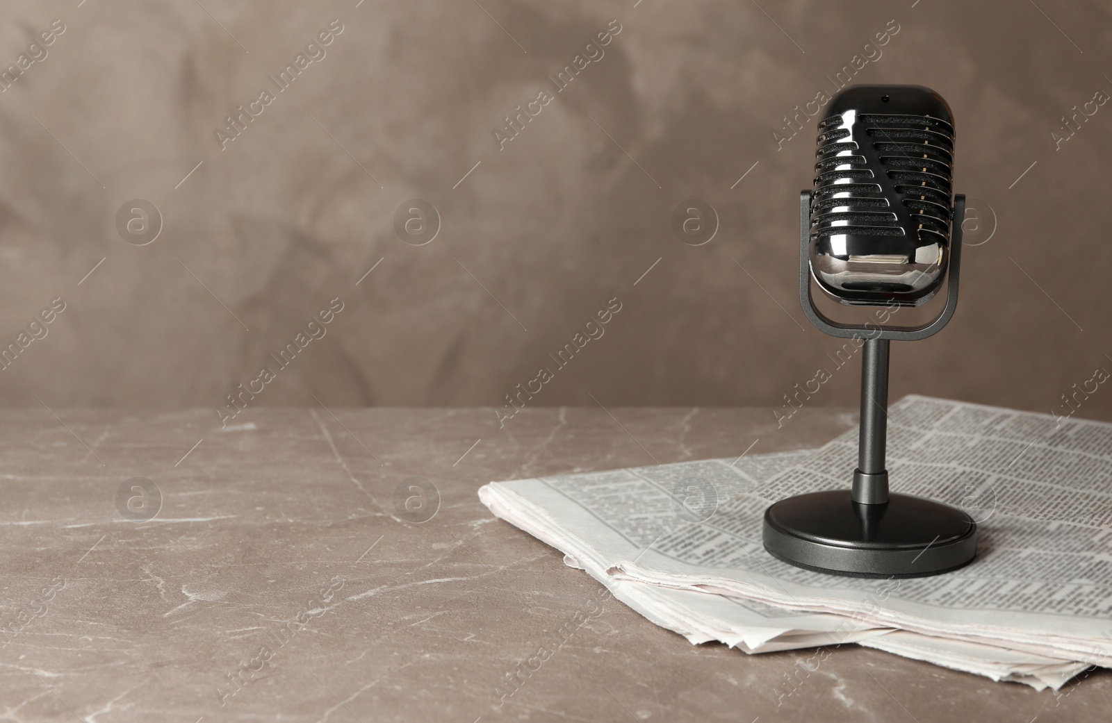 Photo of Newspapers and vintage microphone on marble table, space for text. Journalist's work