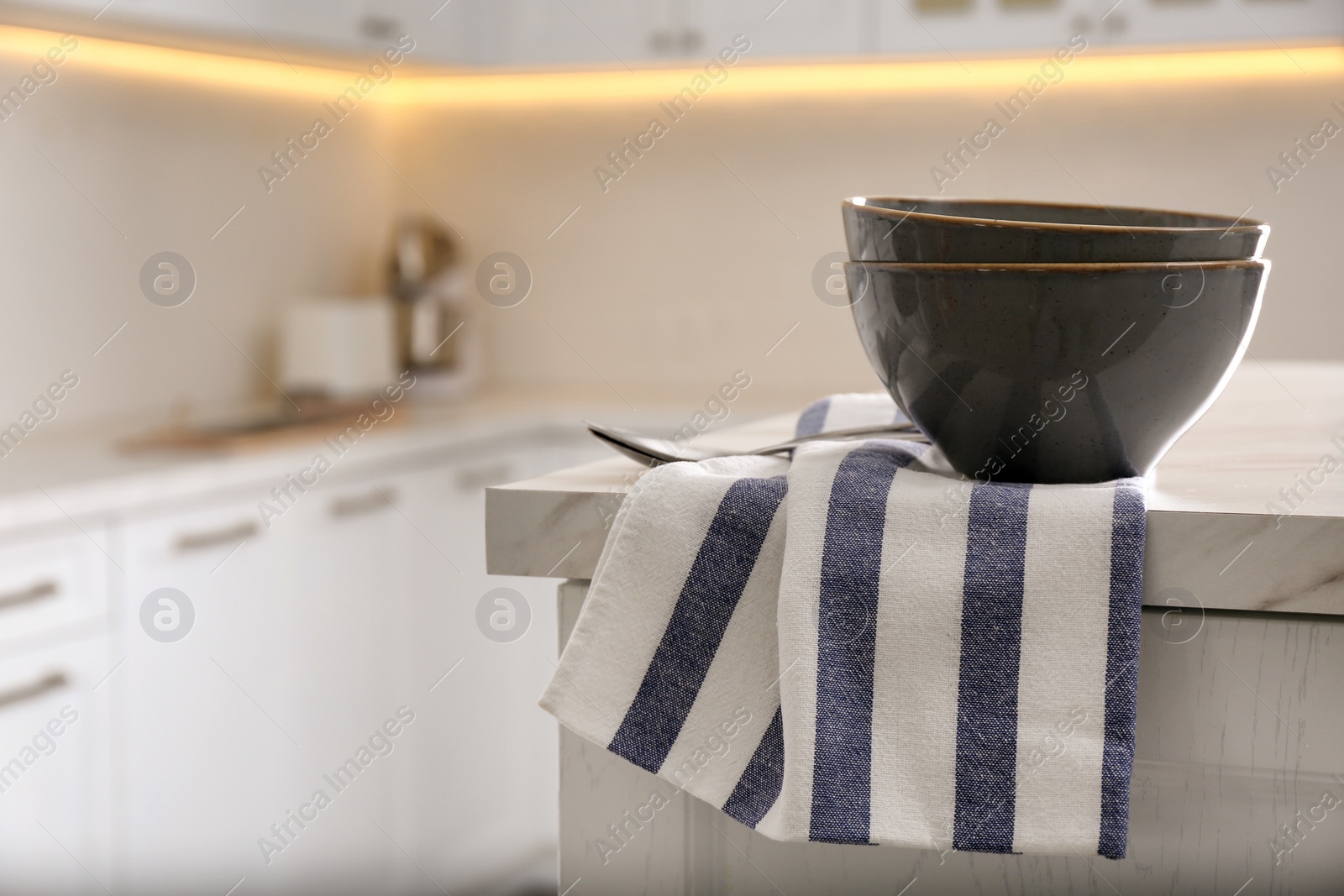 Photo of Kitchen towel and bowl on white table indoors, space for text